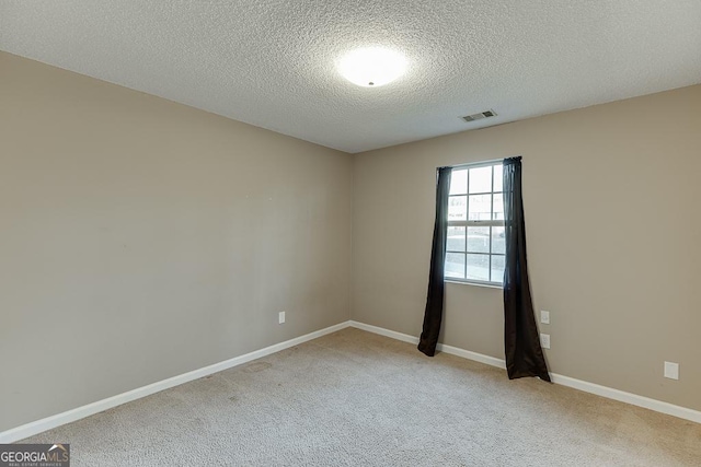 carpeted spare room with a textured ceiling