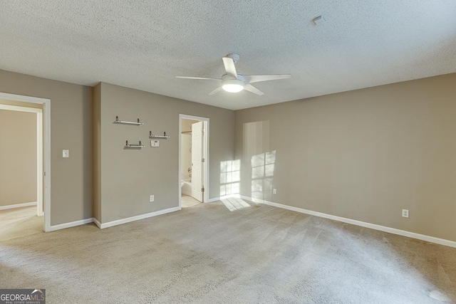 unfurnished room with ceiling fan, light colored carpet, and a textured ceiling