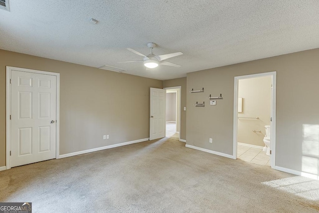 spare room with a textured ceiling, light colored carpet, and ceiling fan