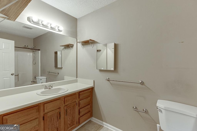 bathroom with vanity, a shower, tile patterned floors, toilet, and a textured ceiling