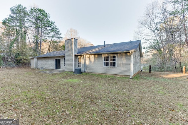 rear view of house with a lawn and cooling unit