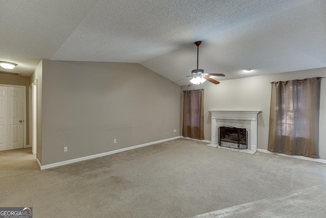 unfurnished living room featuring a high end fireplace, light carpet, ceiling fan, and lofted ceiling