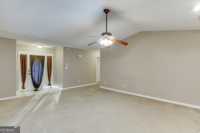 spare room featuring light carpet and vaulted ceiling