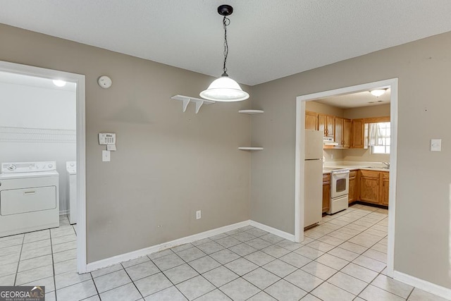 unfurnished dining area with washer and dryer, light tile patterned floors, and sink