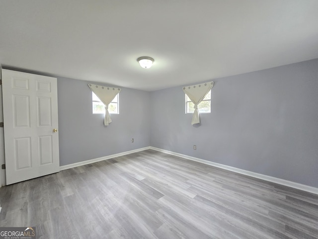 spare room featuring a wealth of natural light and hardwood / wood-style floors