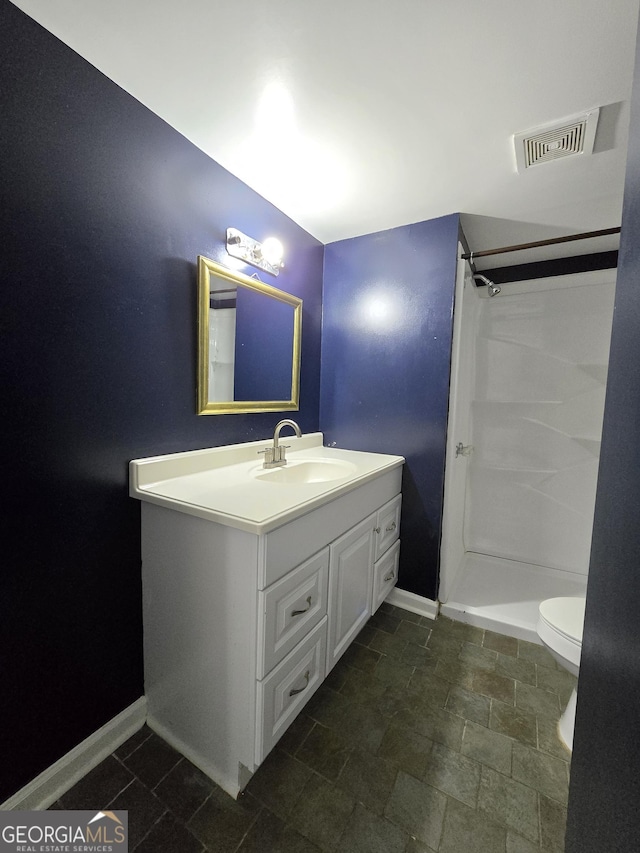 bathroom with vanity, toilet, and walk in shower