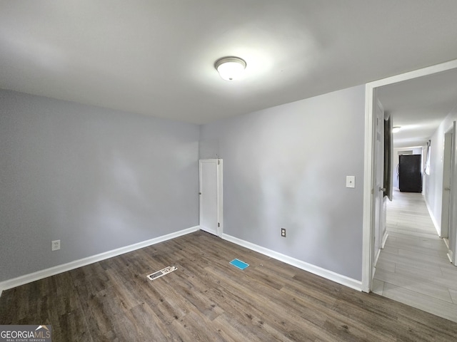 unfurnished room with wood-type flooring