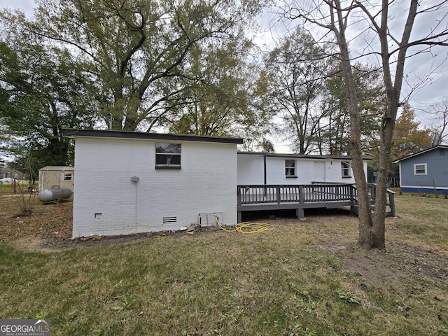 rear view of house featuring a deck and a yard