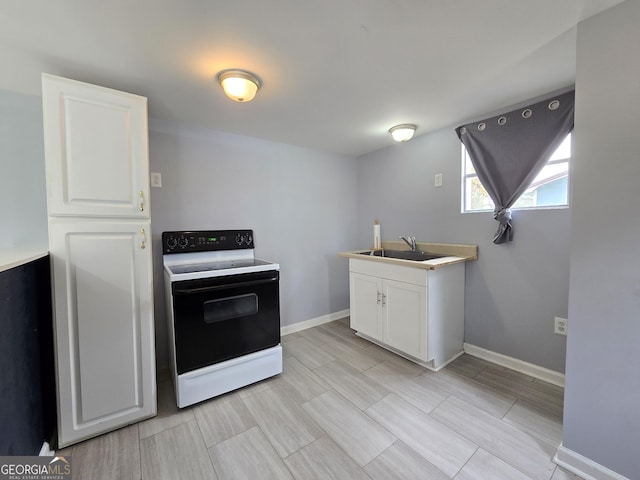 kitchen with sink, white cabinets, and white electric stove