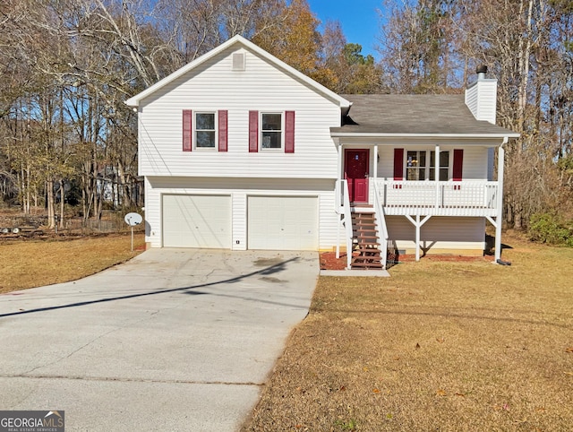 tri-level home featuring a front lawn, covered porch, and a garage