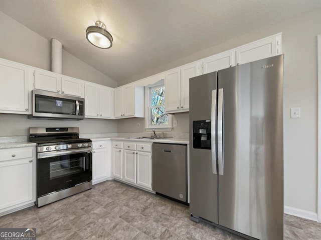 kitchen with sink, white cabinets, lofted ceiling, and appliances with stainless steel finishes