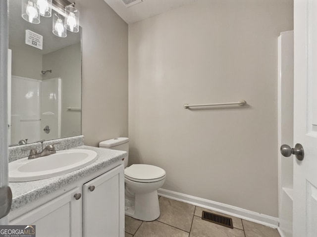 bathroom featuring toilet, a shower, vanity, and tile patterned floors