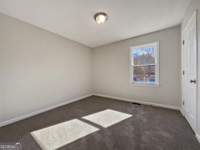 unfurnished bedroom with dark colored carpet