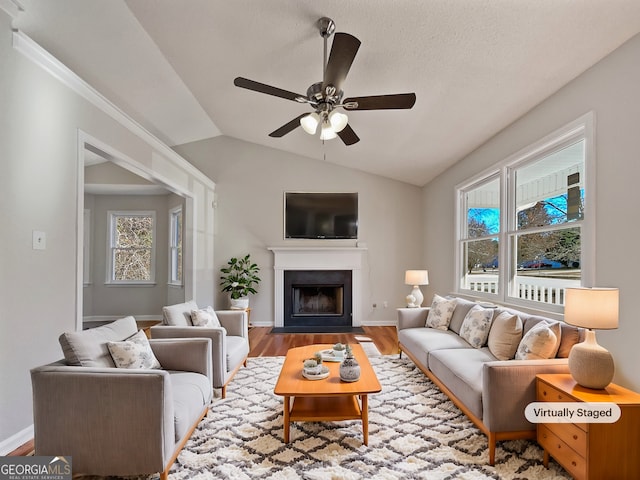 living room featuring hardwood / wood-style floors, ceiling fan, and lofted ceiling