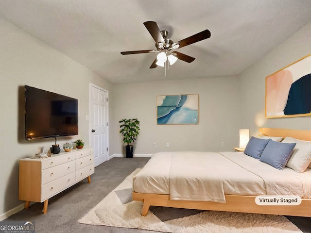 carpeted bedroom with ceiling fan and a textured ceiling