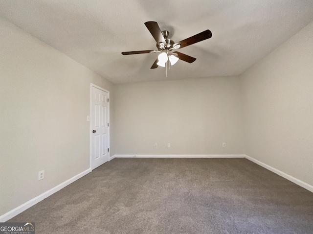 spare room featuring dark colored carpet, ceiling fan, and a textured ceiling