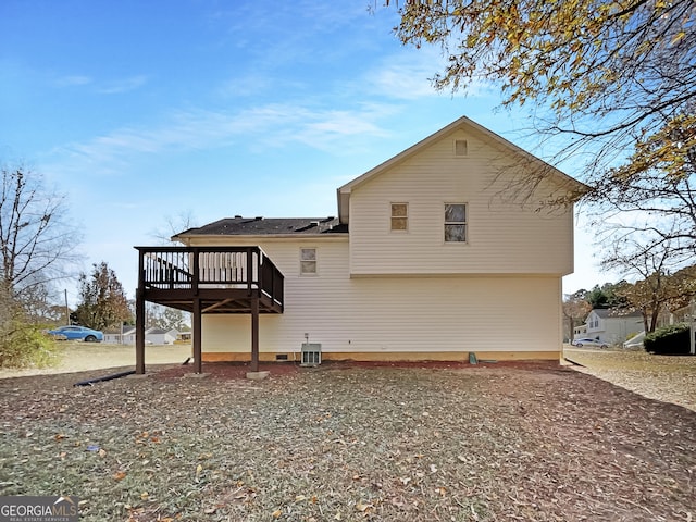 rear view of property featuring cooling unit and a wooden deck