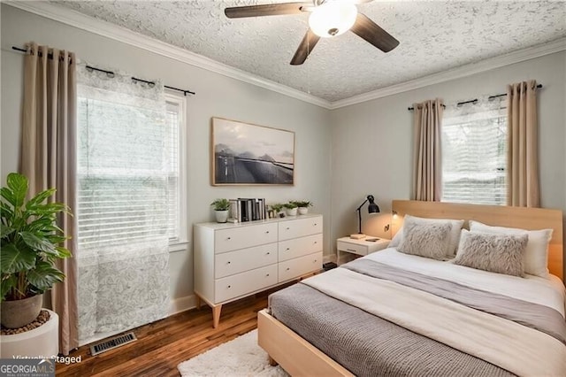 bedroom featuring ceiling fan, dark hardwood / wood-style flooring, crown molding, and a textured ceiling