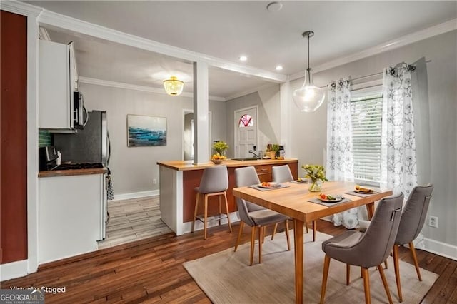 dining room featuring light hardwood / wood-style flooring and ornamental molding