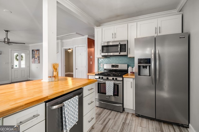 kitchen with wooden counters, appliances with stainless steel finishes, white cabinets, and ceiling fan