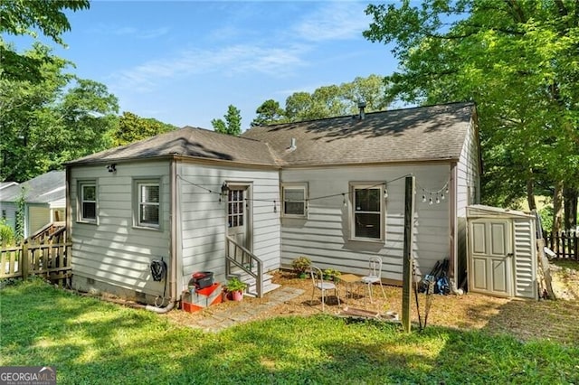 back of property featuring a yard and a shed