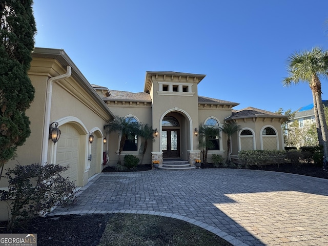 mediterranean / spanish house with french doors and a garage