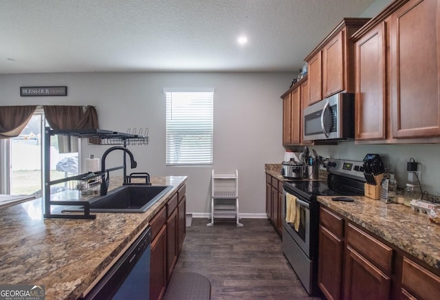 kitchen featuring dark hardwood / wood-style floors, sink, stainless steel appliances, and a wealth of natural light