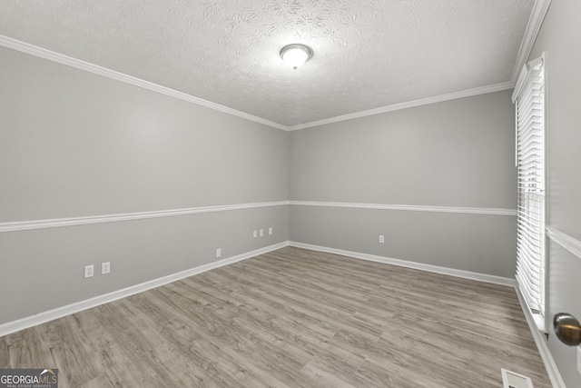 unfurnished room featuring a textured ceiling, hardwood / wood-style flooring, and ornamental molding