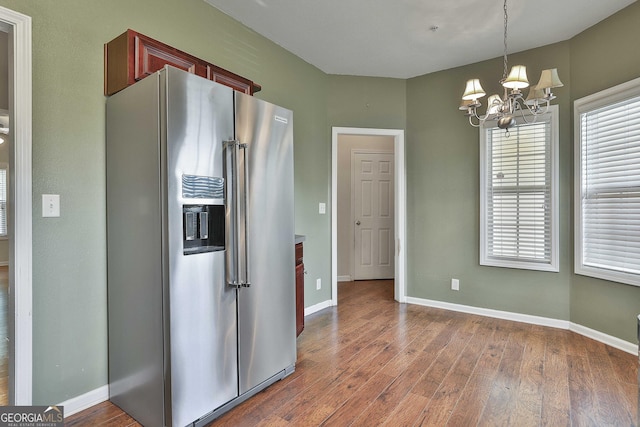 kitchen featuring high end refrigerator, hanging light fixtures, dark hardwood / wood-style floors, and a notable chandelier