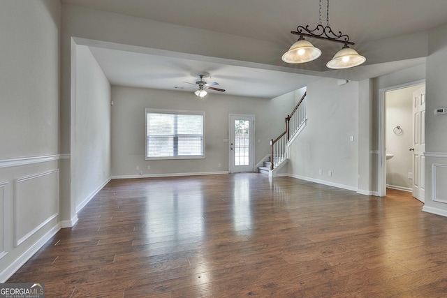 unfurnished living room featuring ceiling fan and dark wood-type flooring