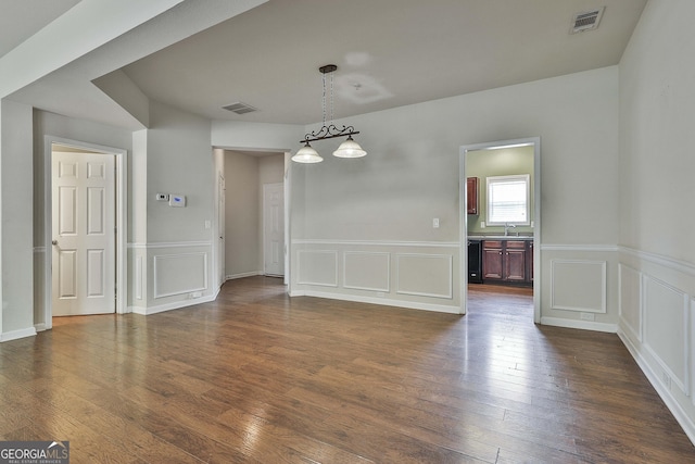 unfurnished dining area with wine cooler, dark hardwood / wood-style flooring, an inviting chandelier, and sink