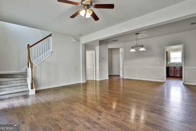 unfurnished living room featuring dark hardwood / wood-style floors, ceiling fan, and sink