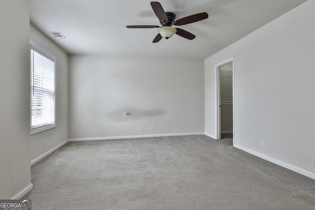 carpeted spare room featuring ceiling fan