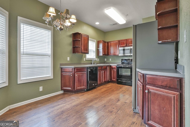 kitchen with sink, hanging light fixtures, an inviting chandelier, wood-type flooring, and black appliances