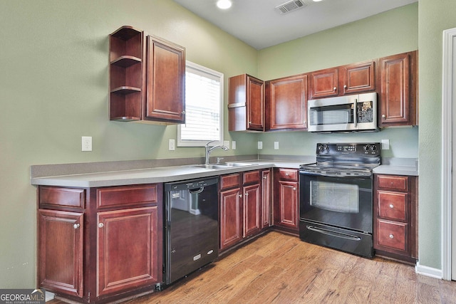 kitchen with sink, light hardwood / wood-style floors, and black appliances