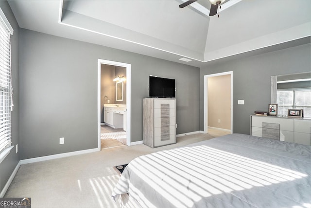 carpeted bedroom featuring vaulted ceiling and ensuite bathroom