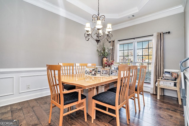 dining room featuring ornamental molding, dark hardwood / wood-style floors, an inviting chandelier, and a tray ceiling