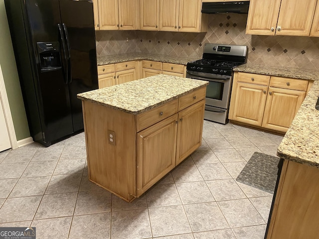 kitchen featuring stainless steel gas stove, light stone counters, tasteful backsplash, a kitchen island, and black fridge with ice dispenser