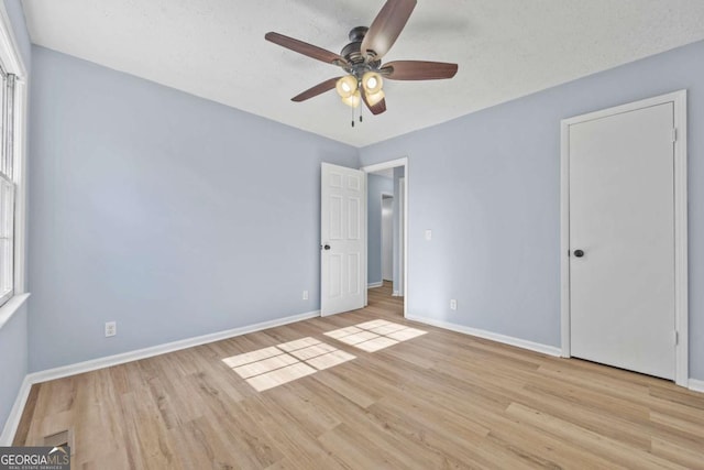 unfurnished bedroom featuring ceiling fan, light hardwood / wood-style floors, and a textured ceiling