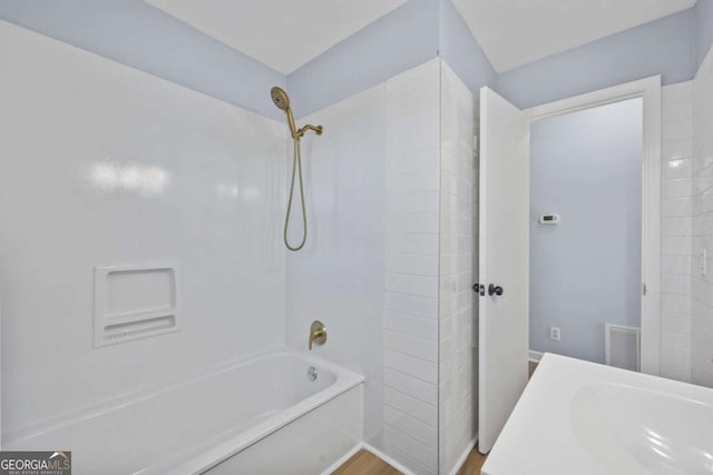 bathroom with bathing tub / shower combination and hardwood / wood-style flooring