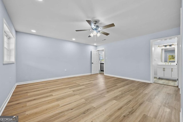 unfurnished bedroom featuring ceiling fan, light hardwood / wood-style floors, and connected bathroom