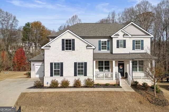 front facade with a porch, a garage, and an outdoor structure