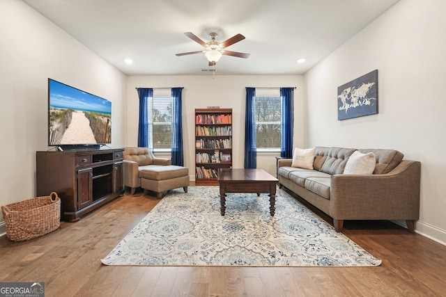 living room featuring ceiling fan and hardwood / wood-style flooring