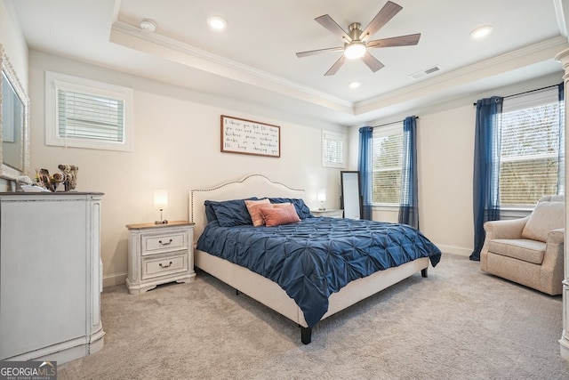 bedroom featuring ceiling fan, multiple windows, light carpet, and a raised ceiling