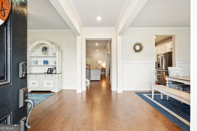 entrance foyer featuring ornamental molding and hardwood / wood-style flooring