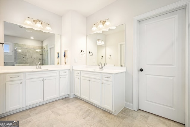 bathroom featuring a shower with door and vanity