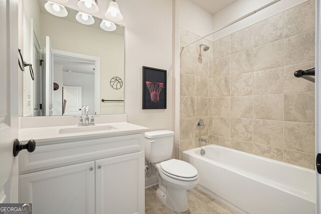 full bathroom with toilet, tiled shower / bath, and vanity