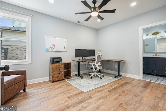 home office featuring sink, ceiling fan, and light hardwood / wood-style floors