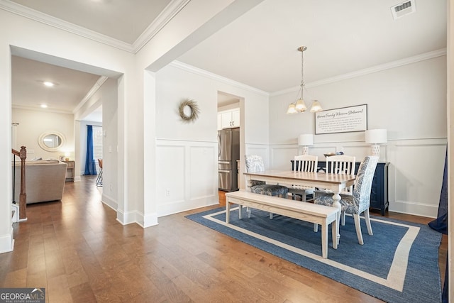 dining room featuring dark wood-type flooring, an inviting chandelier, and crown molding