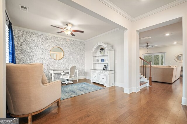 sitting room with hardwood / wood-style flooring, ceiling fan, and crown molding